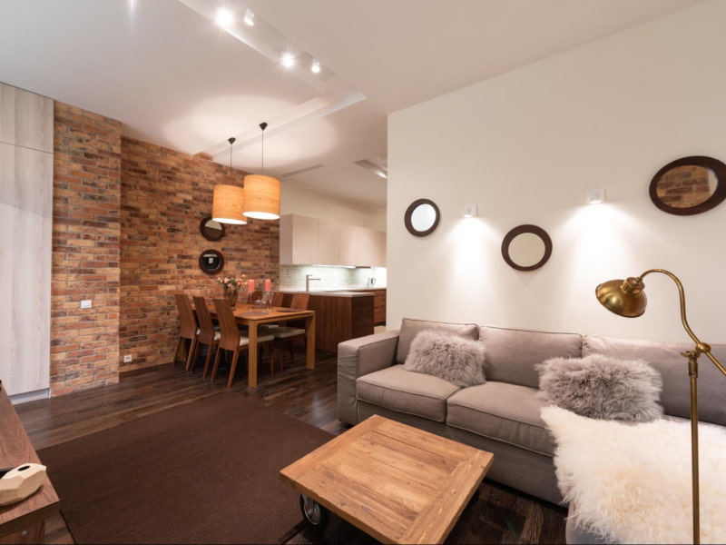 Exposed brick accent wall in the spacious living room - Beautiful Homes