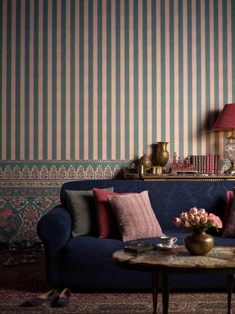 Room with a navy blue sofa and apink and white striped wallpaper