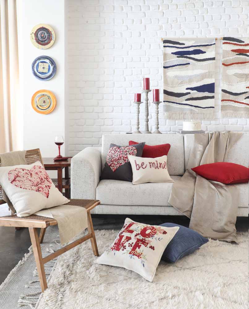 Creative diy wall décor of a living room with colourful rugs & plates - Beautiful Homes