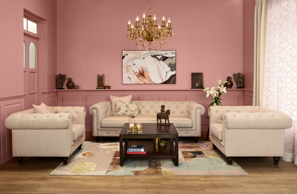 Ornate gold chandelier or jhumar paired with pink living room design - Beautiful Homes