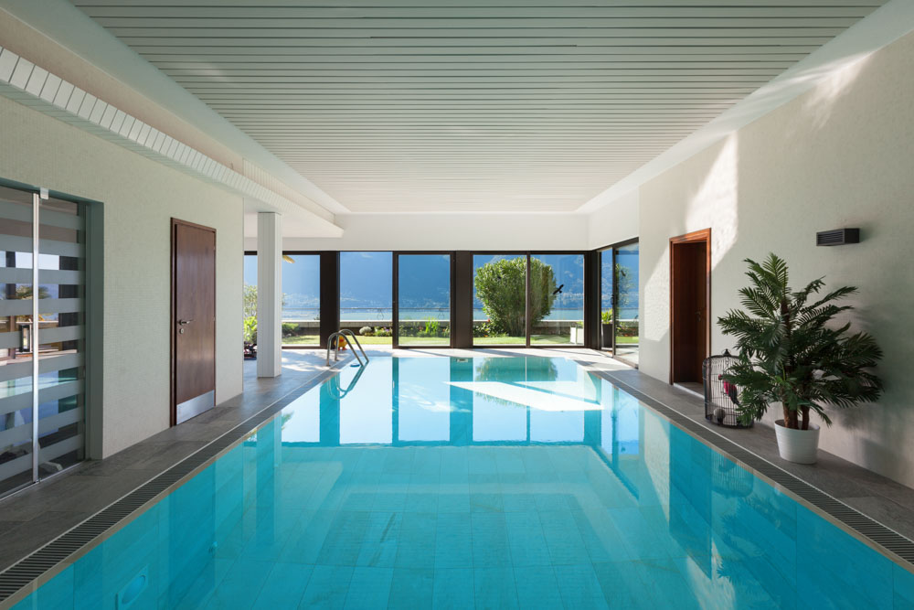 Install glass doors to welcome natural sunlight into your indoor swimming pool - Beautiful Homes