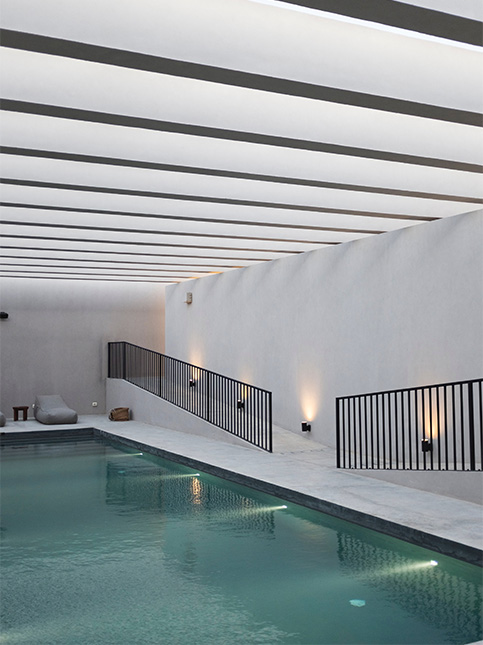 Modern home design interior having a clear blue swimming pool with white interiors - Beautiful Homes