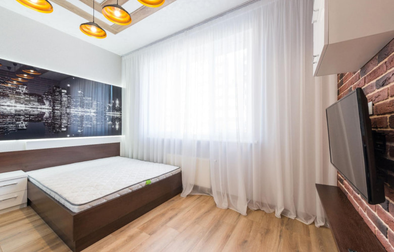 TV mounted on the red brick wall design in the bedroom - Beautiful Homes