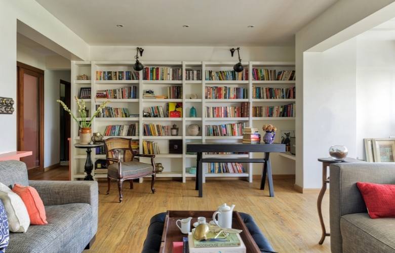 Living room with wooden furniture like book shelf, tables & chair - Beautiful Homes