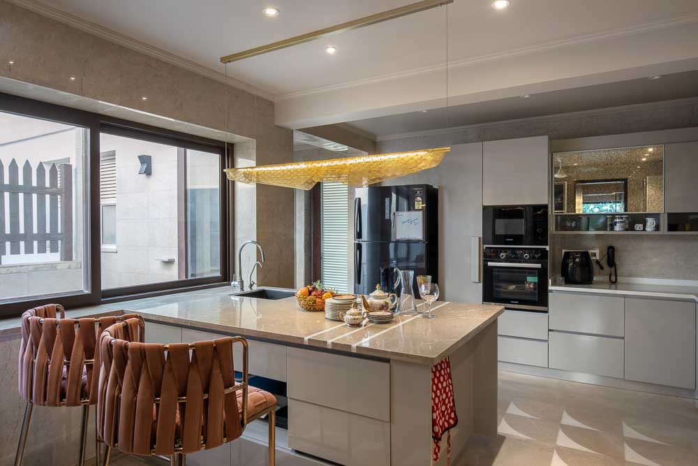 An open kitchen design attached with the living room with a kitchen counter & kitchen island with reduced storage capacity - Beautiful Homes