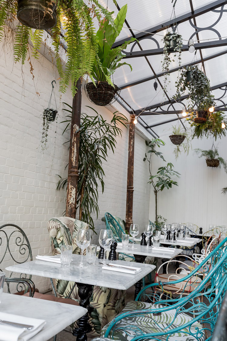 Exposed pipes and wrought iron chairs with a distressed finish mimic the ‘faded glory’ look - Beautiful Homes
