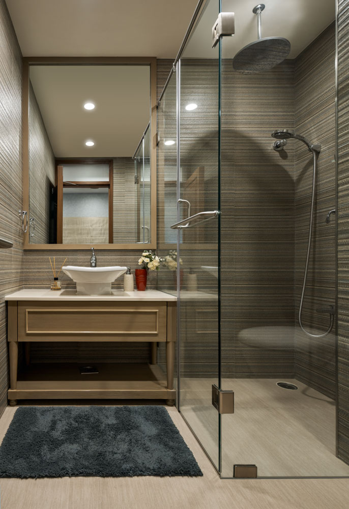 Beige monochrome bathroom with large mirror and off-key dark blue bathmat
