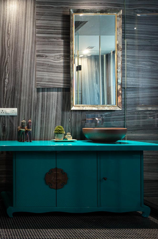 Bathroom with turquoise cabinet, brown wash basin and antique artefacts
