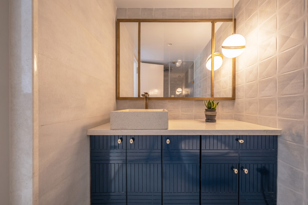 Efficient under-the-sink storage space in a small washroom design in Prussian blue