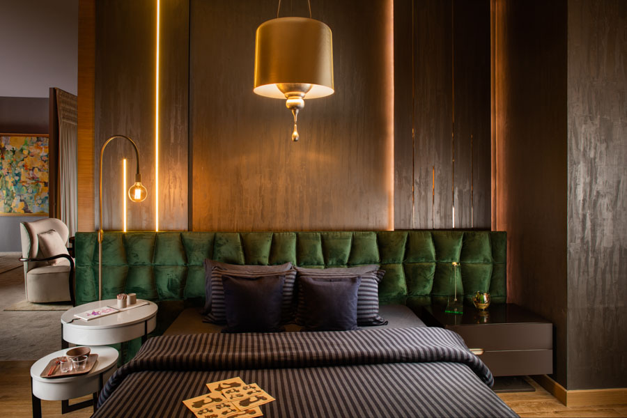 Round and White Bedroom Bedside Table Design With Green Velvet Headboard - Beautiful Homes Round and White Bedroom Bedside Table Design With Green Velvet Headboard and Dark Coloured Bed - Beautiful Homes