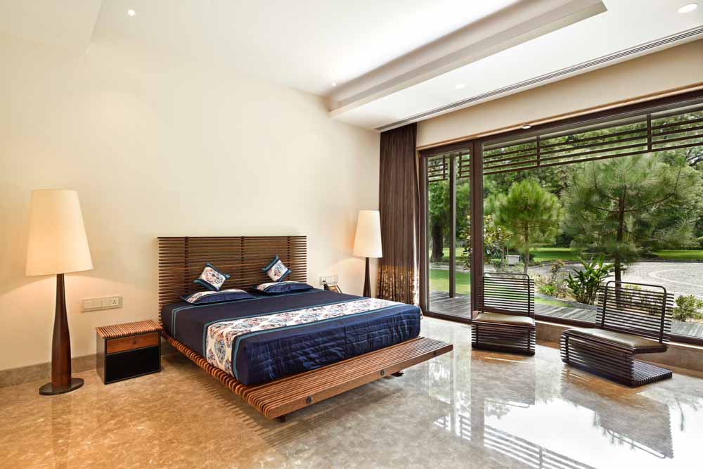 Symmetrical floor lamps near bed create visual balance to the bedroom interior design - Beautiful Homes