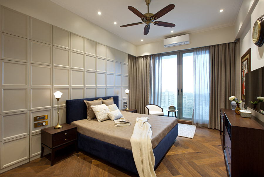 Modern bedroom design with royal blue velvet bed, beige sheets, dark wooden furniture and glass wall