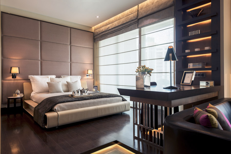Sleek modern bedroom design in dark wood with warm lights and colourful cushions