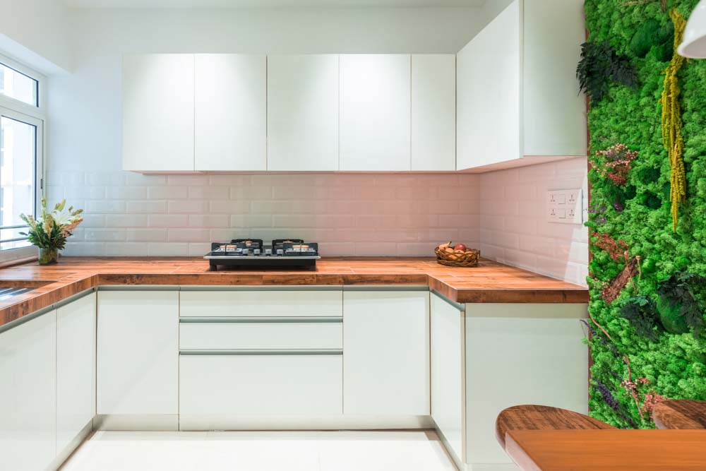 L-shaped kitchen design makeover with white base colour& wooden looking kitchen countertop - Beautiful Homes