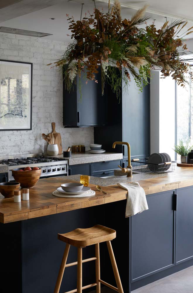 A modular kitchen with textured wall & matte navy blue colour cabinets - Beautiful Homes