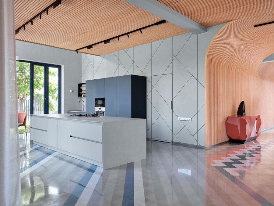 Open-space urban kitchen design in a peach colour next to the garden