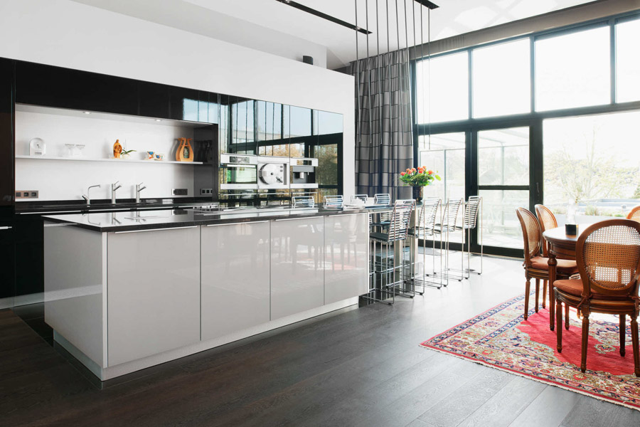 A modern urban kitchen with vintage dining area, wide windows and wooden floor