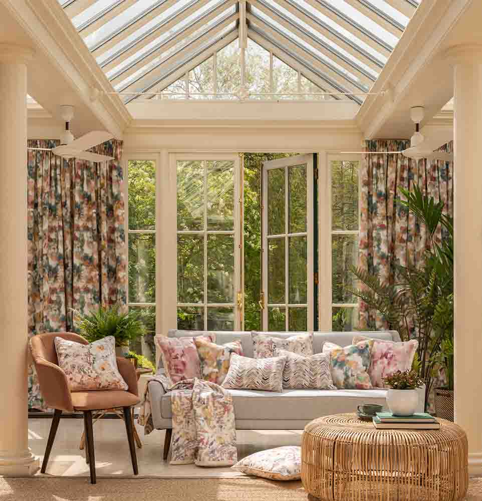 Drawing room decoration with verdant & floral prints on drapes & cushions - Beautiful Homes
