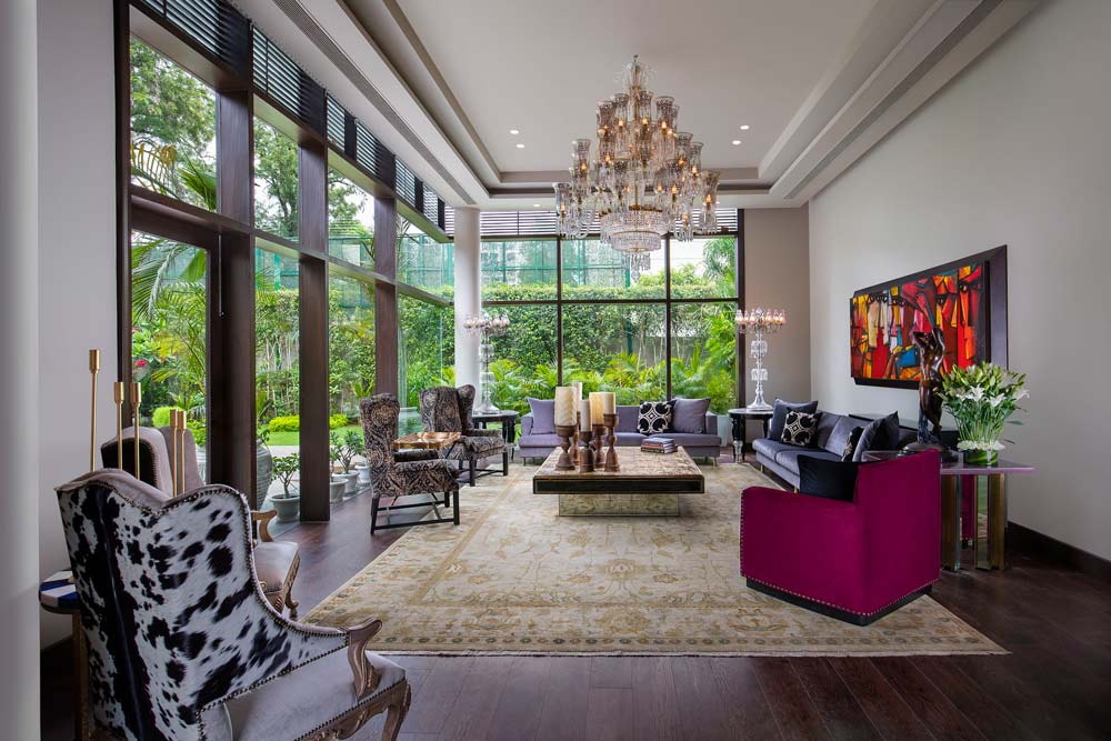 Maximalist drawing room with animal-skin upholstery, bright artwork, statement rug & grand chandelier - Beautiful Homes